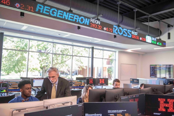 student and professor at computer with bloomberg ticker